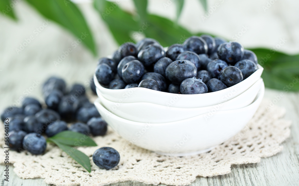 Blueberries in plates on napkin on wooden background Blueberries in plates on napkin on wooden background