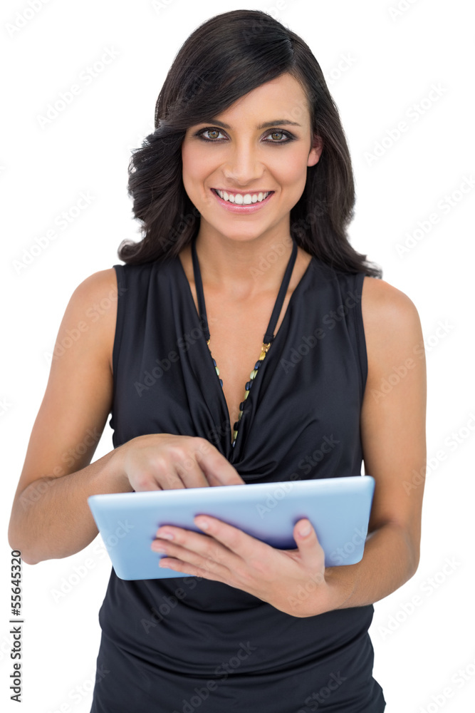 Smiling elegant brown haired model scrolling on tablet pc Smiling elegant brown haired model scrolling on tablet pc
