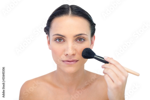 Natural model applying makeup on her face