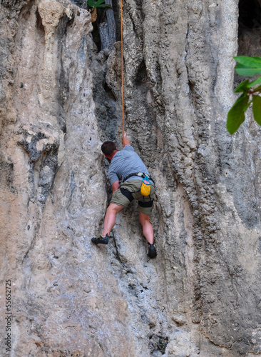 man climbing on the rock route summer