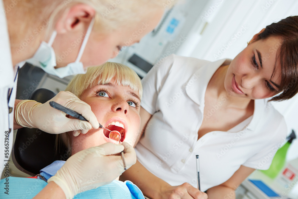 Zahnärztin untersucht Patient