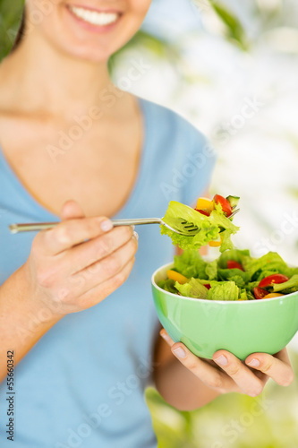 woman eating salad with vegetables