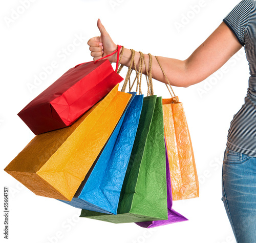 Female hand holding shopping bags and showing ok