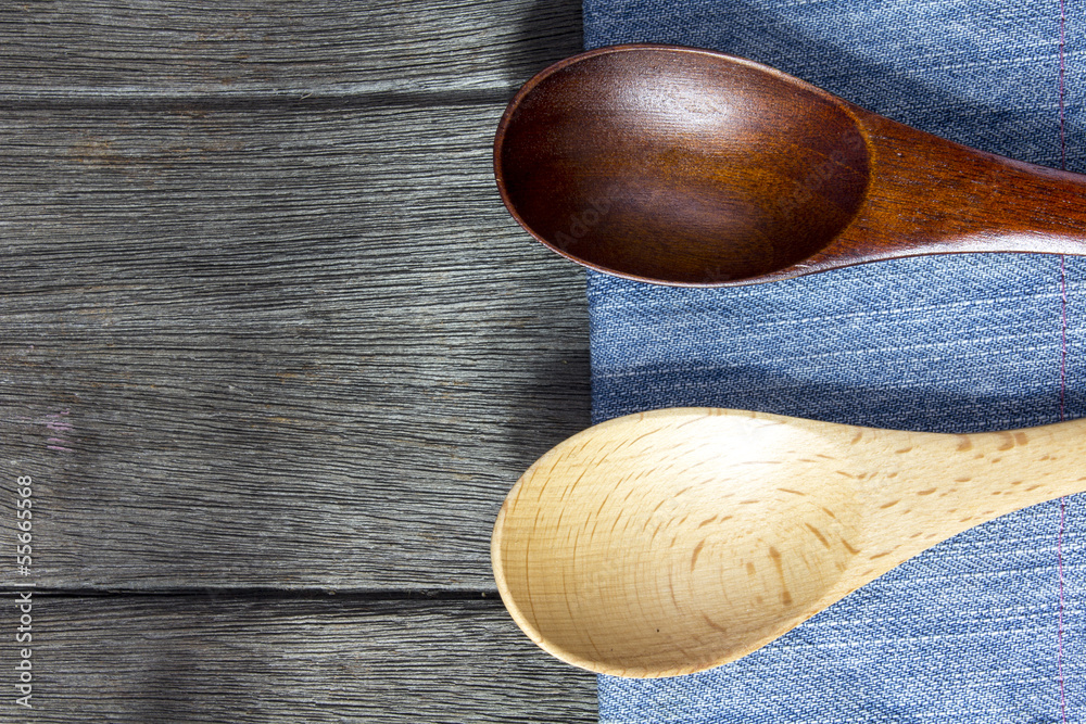 wood background and spoon on blue jeans texture. wood background and spoon on blue jeans texture.