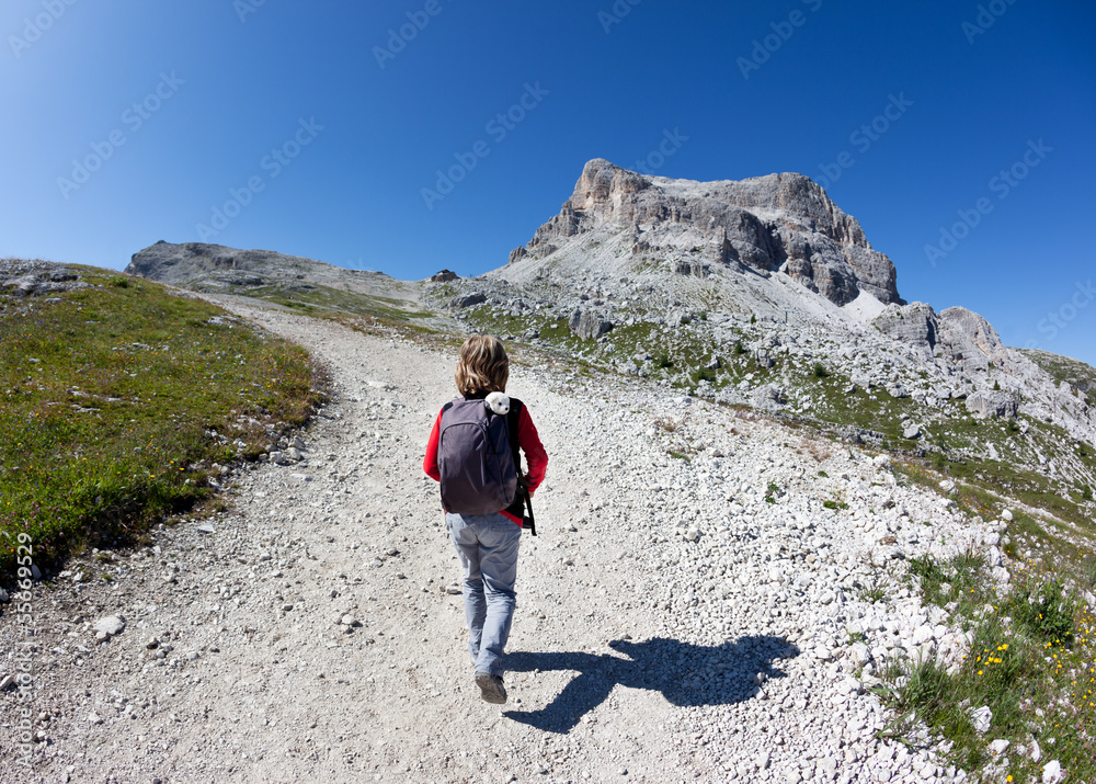 Young hiker walking on a mountain trail.