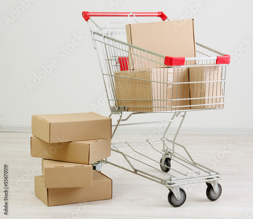 Shopping cart with carton, on gray background