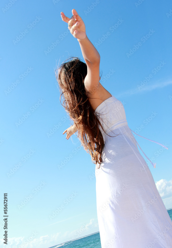 Naklejka premium Woman relaxing at the beach with arms open enjoying her freedom