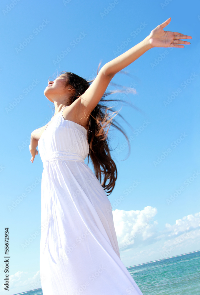 Woman relaxing at the beach with arms open enjoying her freedom Woman relaxing at the beach with arms open enjoying her freedom