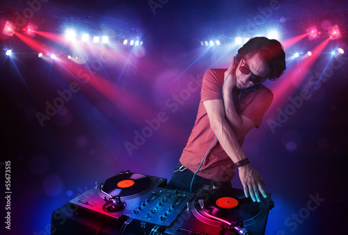 Teenager dj mixing records in front of a crowd on stage