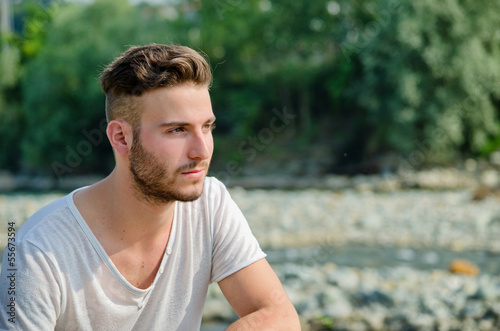 Portrait of handsome young man outdoors in nature