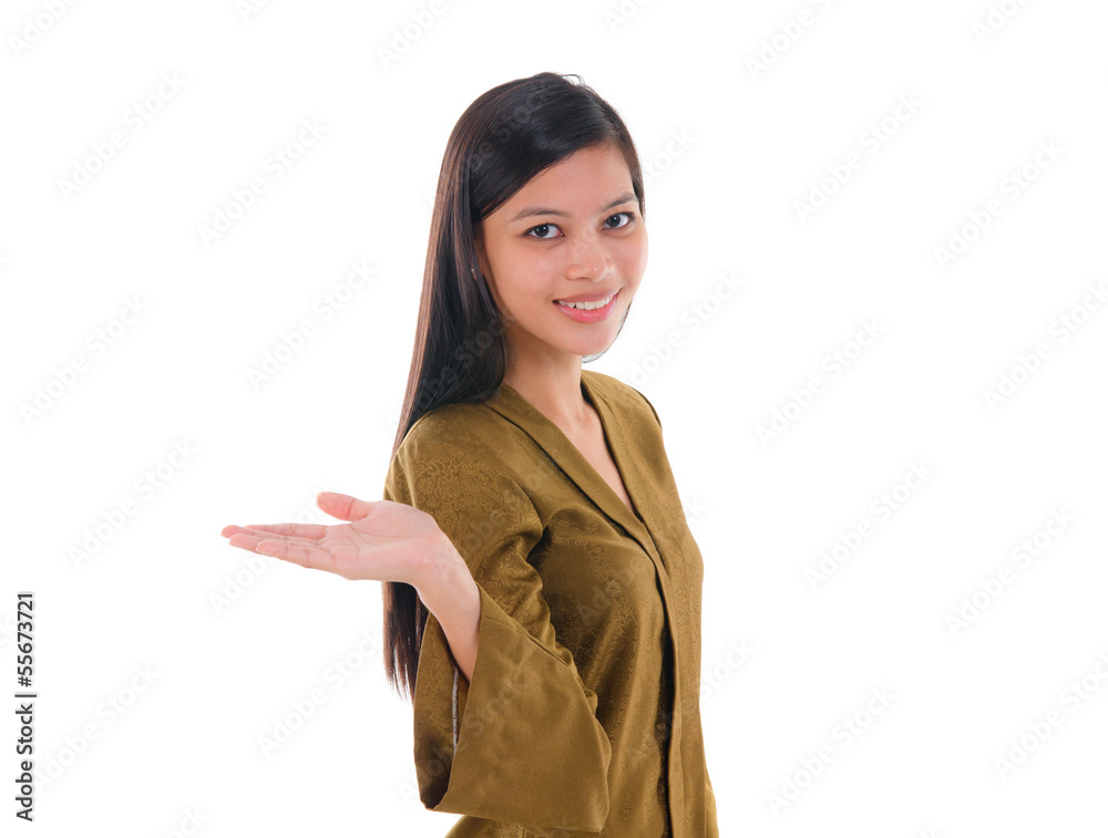 Asian female with batik dress pointing on empty space, over whit Asian female with batik dress pointing on empty space, over whit