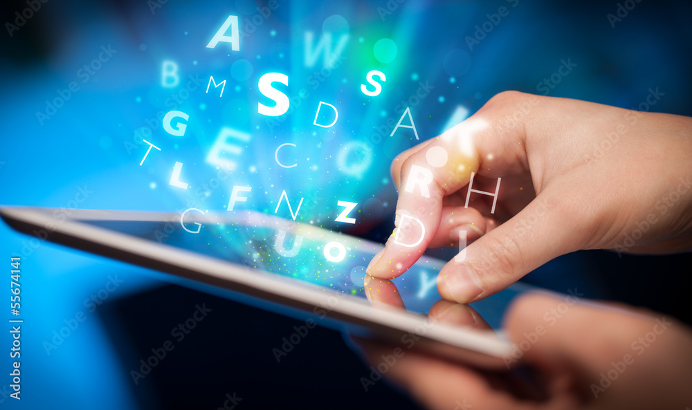 Finger pointing on tablet pc, letters concept Finger pointing on tablet pc, letters concept