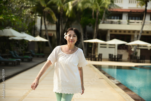 Portrait of woman walking near swimming pool on hotel
