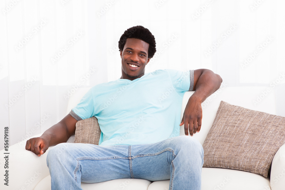 Young Man Sitting On Couch Stock Photo | Adobe Stock