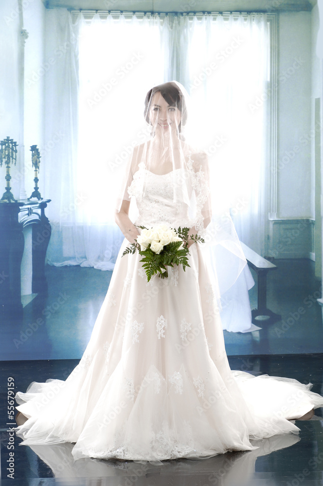 young and beautiful bridge in whit dress holding flowe