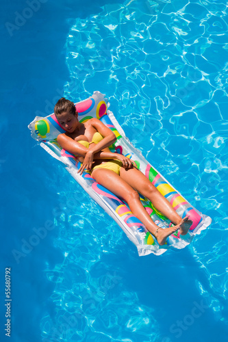 A girl is relaxing in a swimming pool