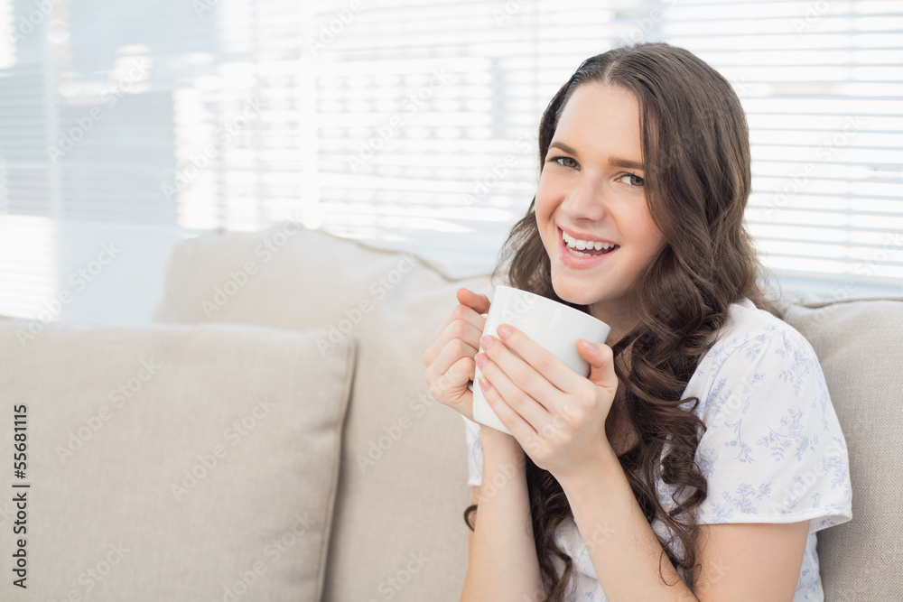 Cheerful young woman in pyjamas having coffee Cheerful young woman in pyjamas having coffee