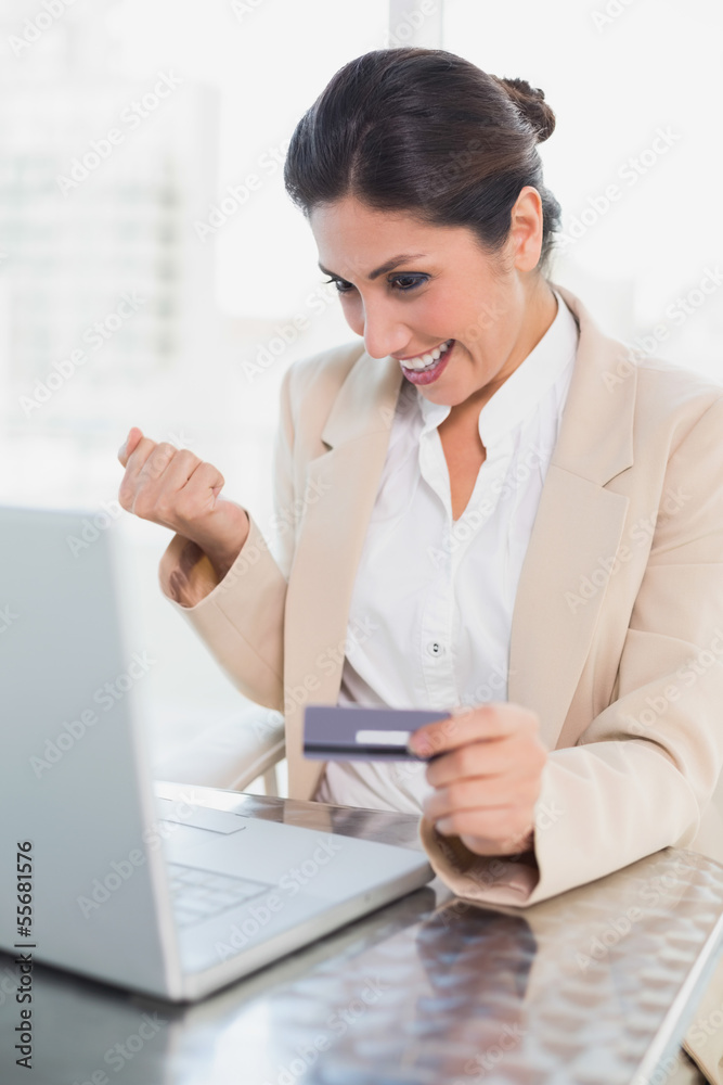 Excited businesswoman shopping online with laptop Excited businesswoman shopping online with laptop