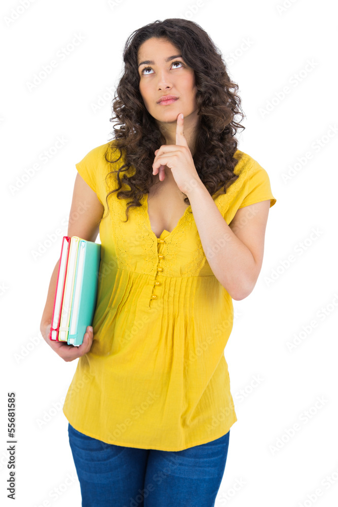 Pensive curly haired student holding notebooks Pensive curly haired student holding notebooks
