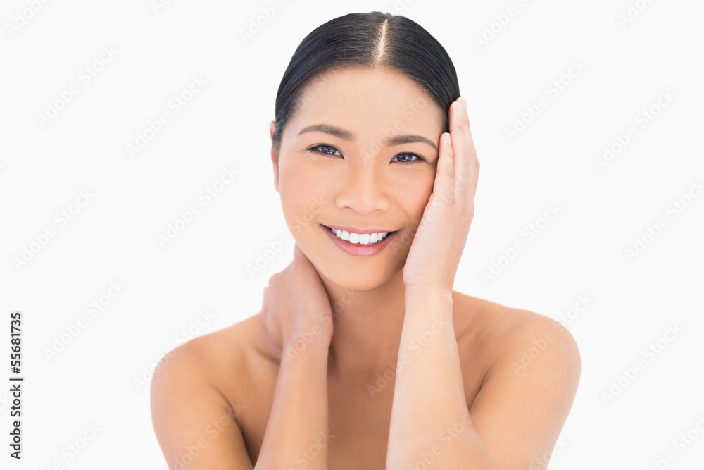 Smiling natural dark haired model touching her face Smiling natural dark haired model touching her face