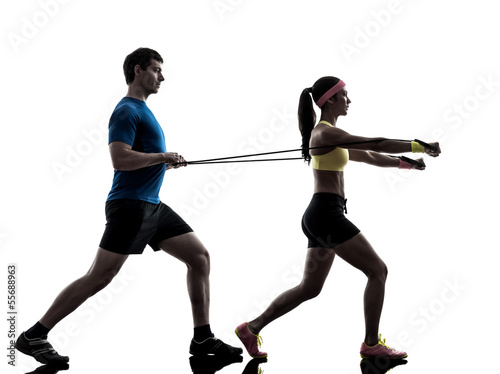 woman exercising fitness resistance rubber band with man coach
