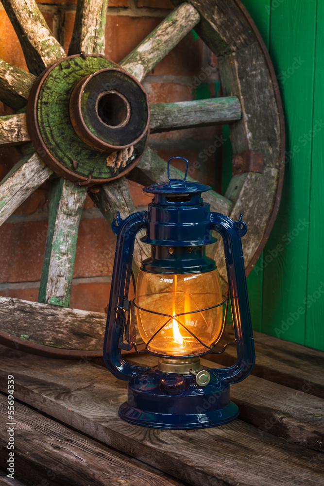 kerosene lamp against the background wagon wheel kerosene lamp against the background wagon wheel