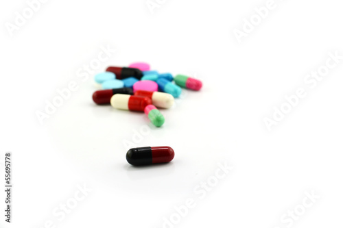 Colorful medical pills and capsules on white background.