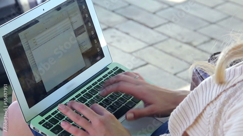 Laptop screen young woman hands type letter e-mail in park photo