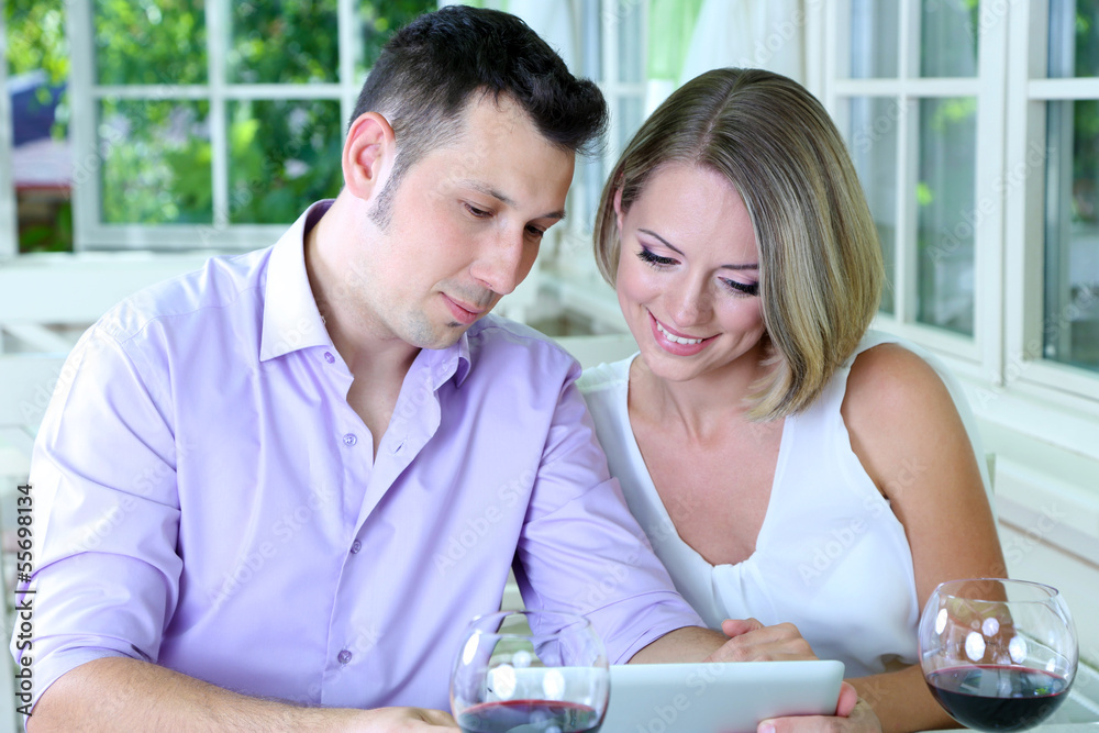 Young couple  taking photo with tablet in restaurant