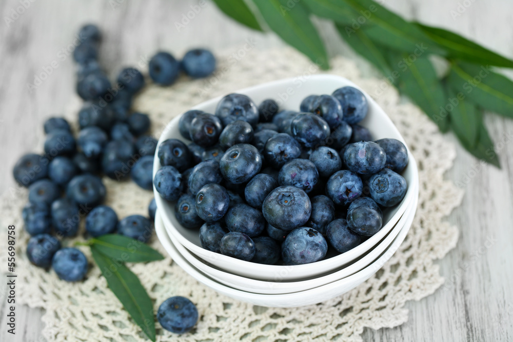 Blueberries in plates on napkin on wooden background Blueberries in plates on napkin on wooden background