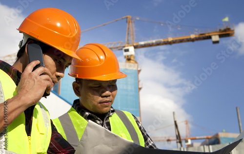Construction worker looking at blueprint at construction site