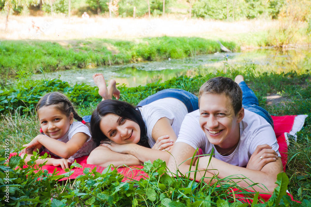 Fototapeta premium Family lying on a red blanket