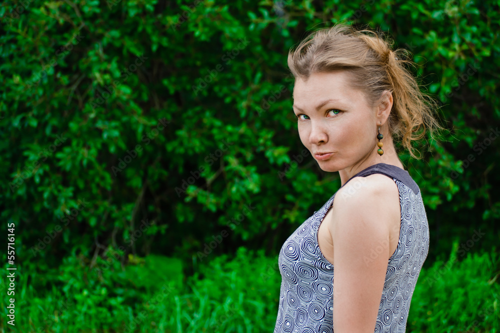 Capricious woman against green summer background Capricious woman against green summer background