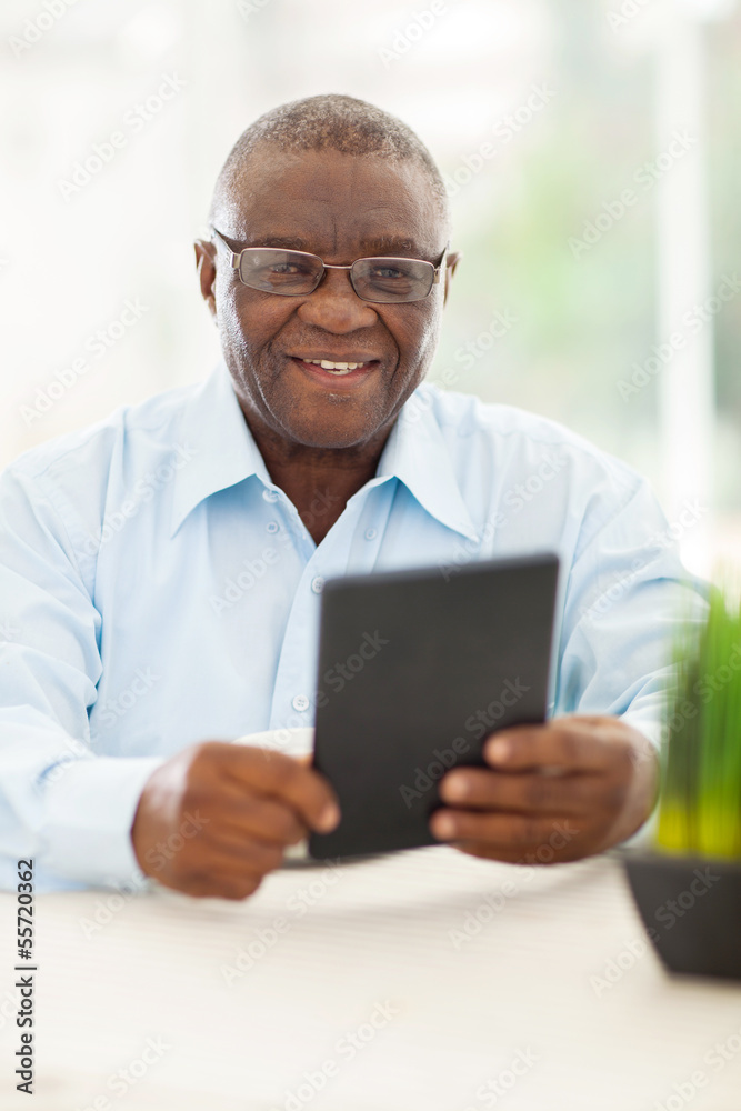 senior african man holding tablet computer