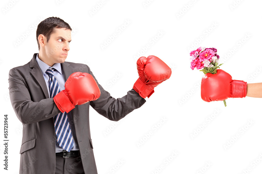 Angry man with boxing gloves hitting a hand with boxing glove Angry man with boxing gloves hitting a hand with boxing glove