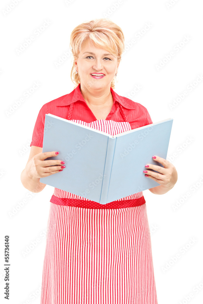 Smiling mature female cooker wearing an apron and cookbook Smiling mature female cooker wearing an apron and cookbook