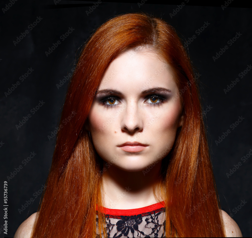 Fototapeta premium Young beautiful red hair woman in dark studio