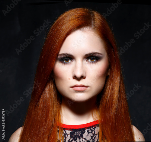Fototapeta Naklejka Na Ścianę i Meble -  Young beautiful red hair woman in dark studio