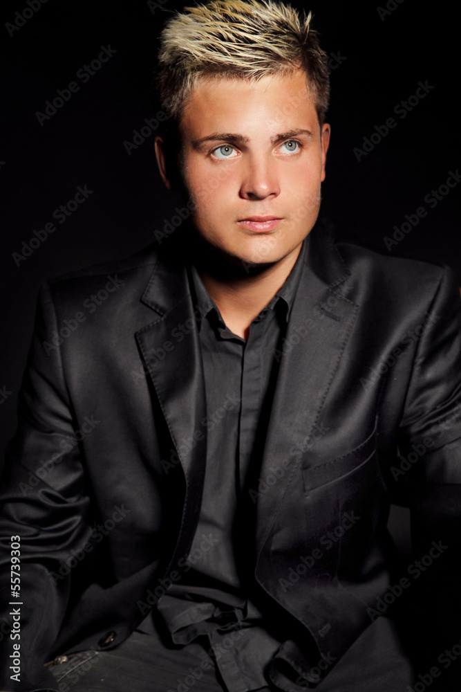 Obraz premium Elegant young handsome man over dark. Studio fashion portrait.