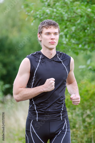 Handsome sportsman running in park