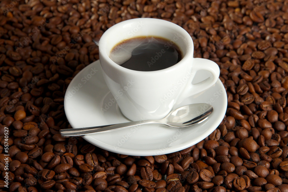 Cup of coffee on coffee beans background