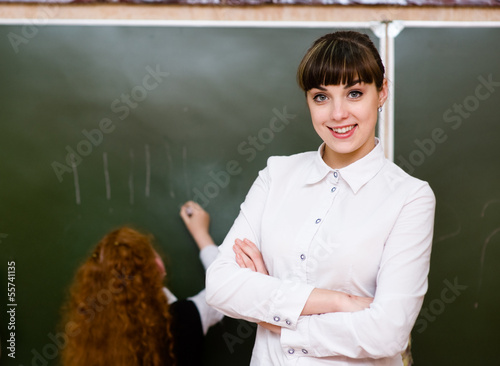Portrait of teacher standing near blackboard