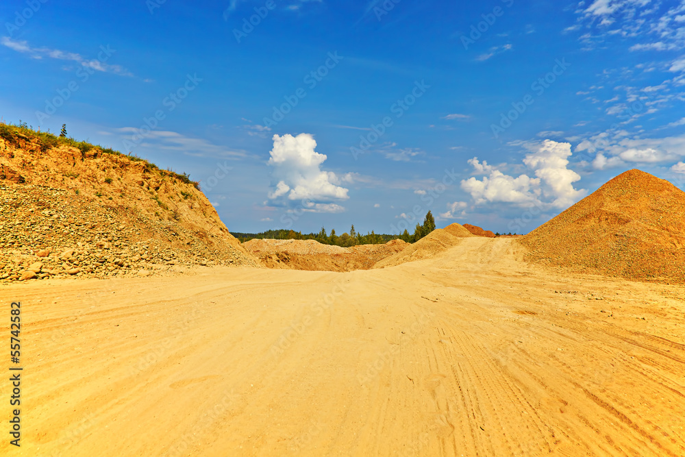 sandy road between hills in sunny summer day