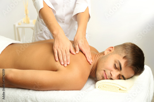 Young man having back massage close up