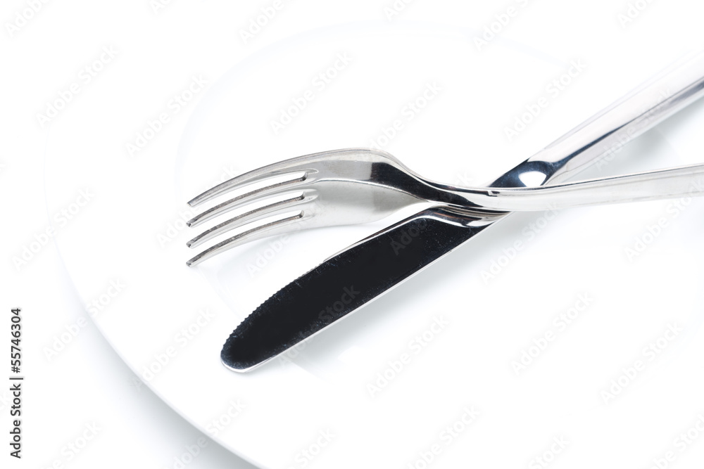 fork and knife on a white plate, close-up selective focus fork and knife on a white plate, close-up selective focus