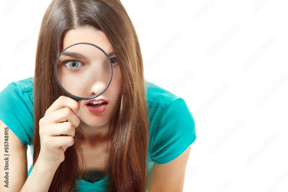 Beautiful teen girl looking through a magnifying glass over whit Beautiful teen girl looking through a magnifying glass over whit