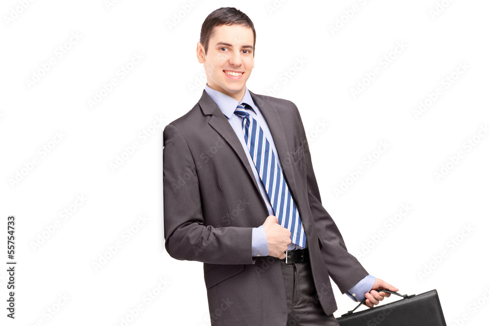 Smiling businessman holding a leather briefcase and leaning Smiling businessman holding a leather briefcase and leaning