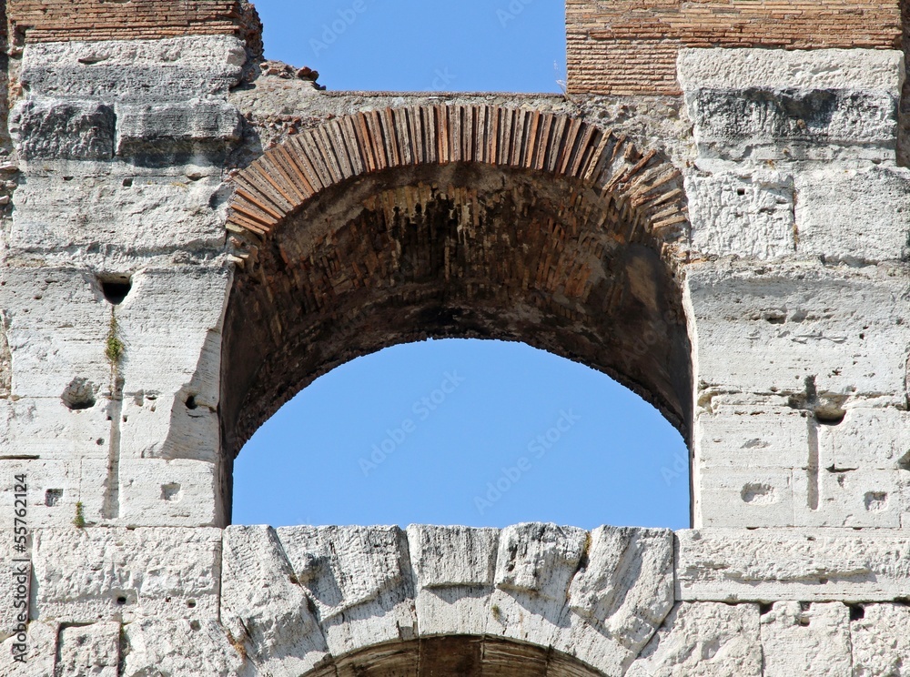 ancient Arch of the Colosseum and the blue sky of Rome in Italy