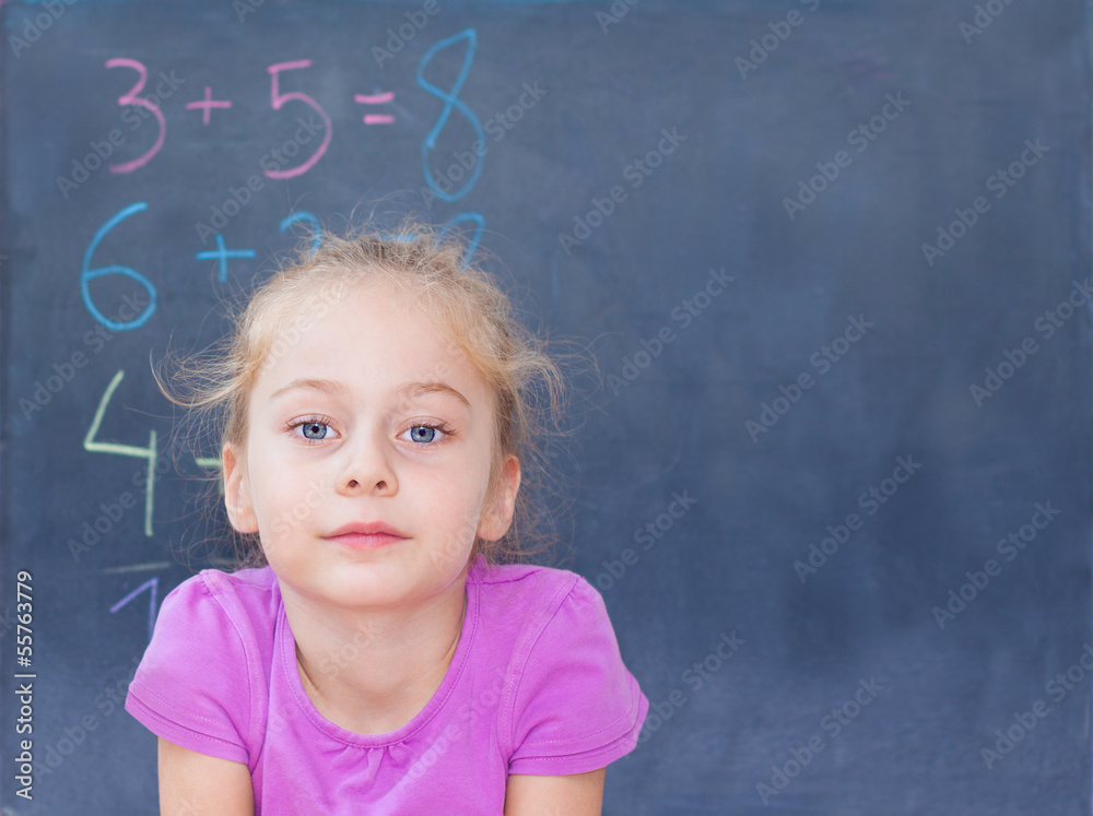 Young blond caucasian girl in front of blackboard Young blond caucasian girl in front of blackboard