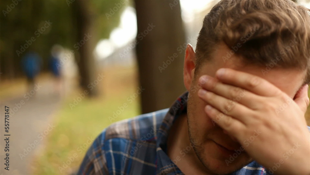 Depressed, sad young man sitting in the park, 1080p Depressed, sad young man sitting in the park, 1080p